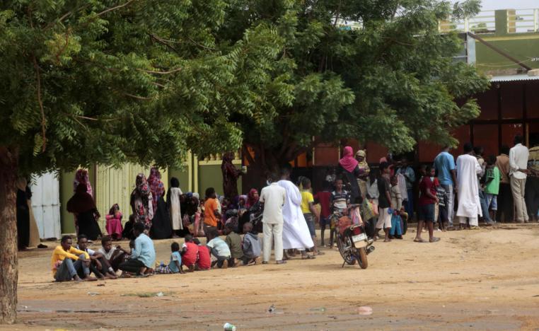 People stand in a queue outside a bakery in the central Sudanese city of Al-Obeid