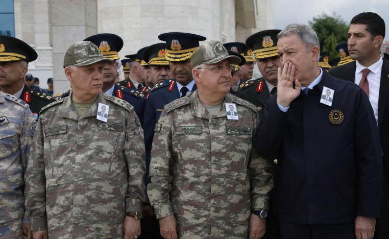 Turkey's Defense Minister Hulusi Akar, right, speaks with army's top commanders during the funeral of Turkish diplomat Osman Kose