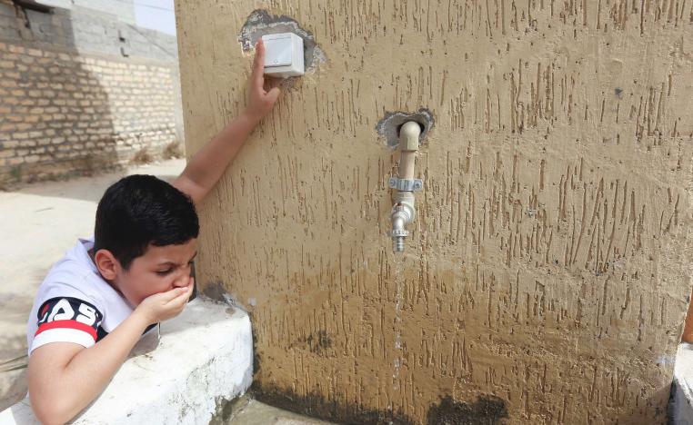 A boy drinks water during a water shortage in Tripoli, Libya