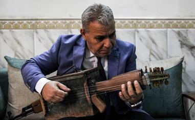 الموسيقي العراقي ماجد عبدالنور يعزف على آلة شبيهة بالعود 
