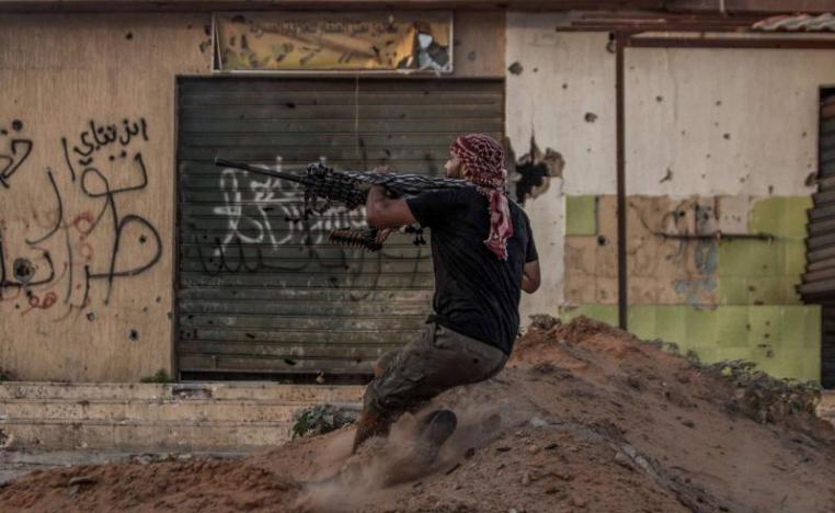 A fighter loyal to Libya's UN-backed Government of National Accord (GNA) fires his machine gun, at the Salah al-Din front line