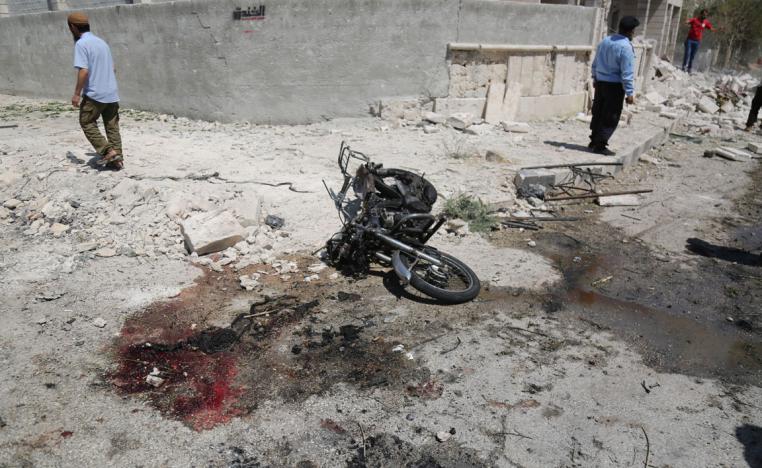 Blood seen next to a damaged motorcycle after an explosion hits a residential neighbourhood in Idlib