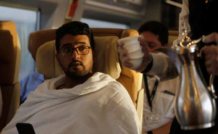 A Pilgrim on his way to Mecca is served Arabic coffee on the Haramain High-Speed Railway train in the holy city of Medina