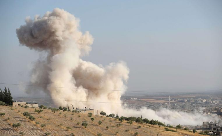 Smoke billowing above buildings during a reported air strike by pro-regime forces in Idlib province