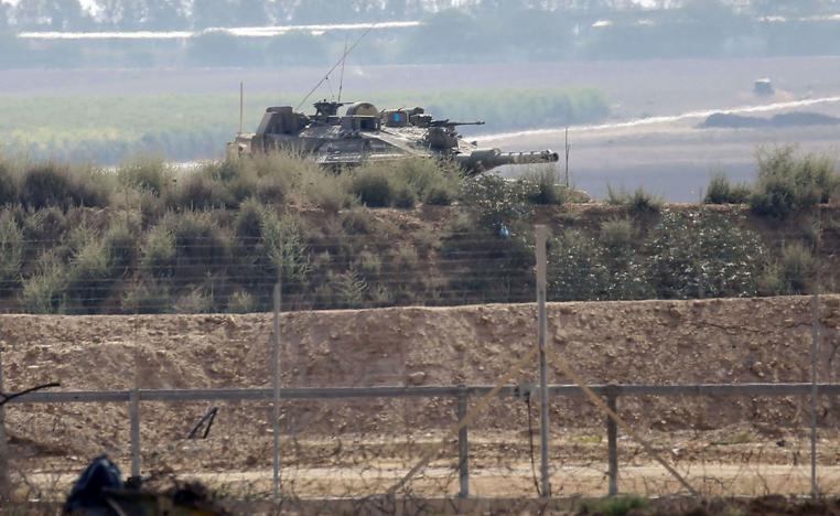 A picture taken from Khan Yunis shows an Israeli tank inspecting the area across the border fence with the southern Gaza Strip