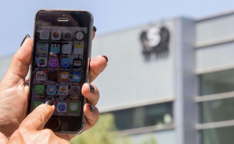 An Israeli woman uses her smartphone in front of the building housing the Israeli NSO group