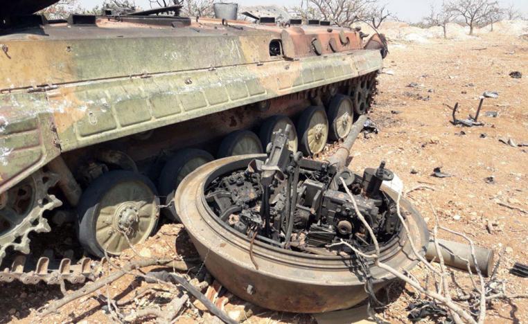 A damaged military tank is seen in Idlib countryside, Syria