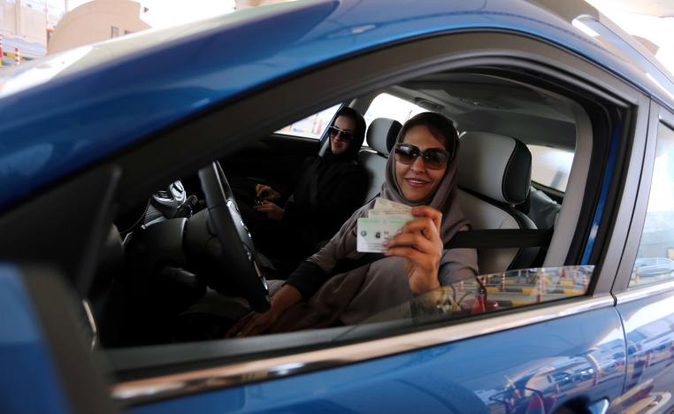 A Saudi woman smiles with her national ID at the Bahrain immigration checkpoint