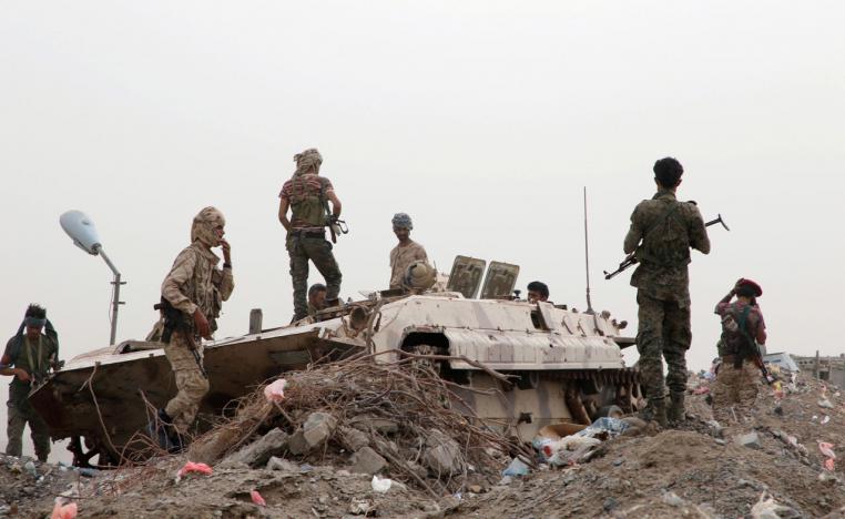 Members of STC military forces stand by a military vehicle during clashes with government forces in Aden
