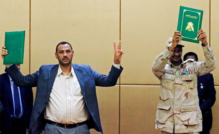 Deputy Head of Sudanese Transitional Military Council, Mohamed Hamdan Dagalo and Sudan's opposition alliance coalition's leader Ahmad al-Rabiah hold up signed copies of the constitutional declaration during a signing ceremony in Khartoum