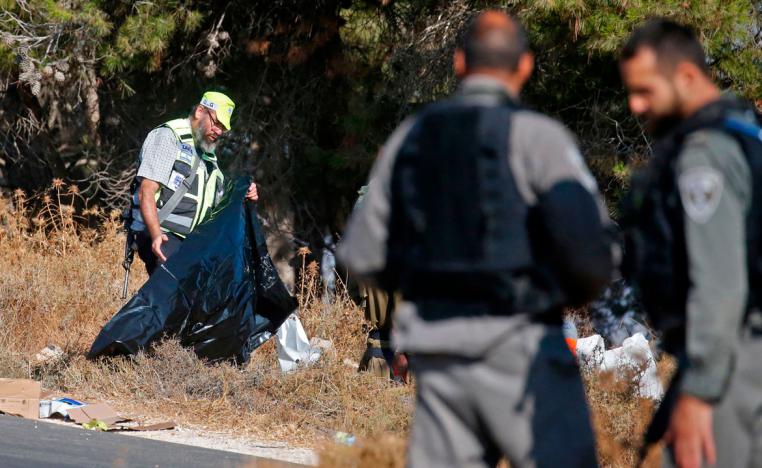 Israeli soldiers and a forensic expert inspect the scene where the body of an Israeli soldier was found with multiple stabs near the settlement of Migdal Oz in the occupied West Bank on August 8, 2019