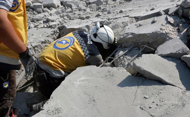 Syrian Civil Defense worker searching for victims from under the rubble of a destroyed building