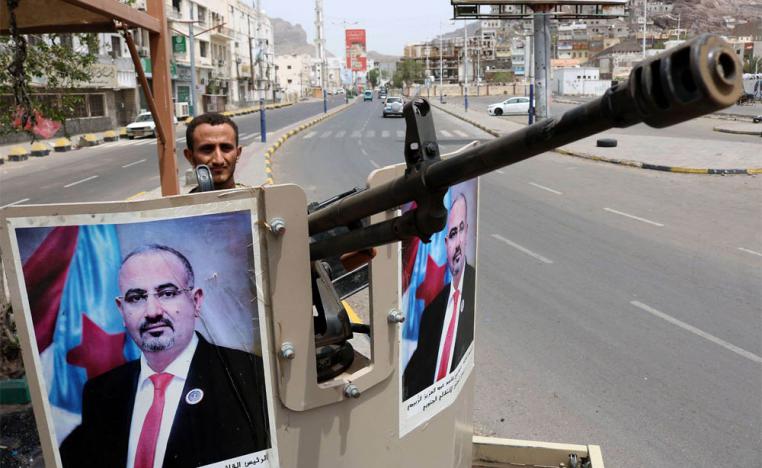 جندي من المجلس الانتقالي يرفع صورة زعيم المجلس عيدروس الزبيدي