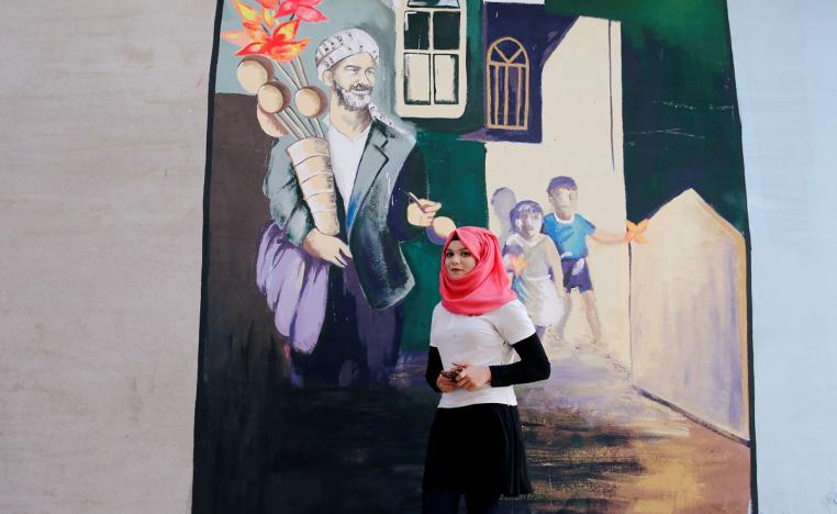 فنانة عراقية أمام جدارية في الموصل