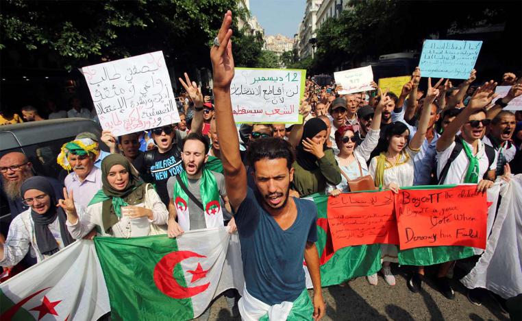 Demonstrators carry flags and banners during a protest rejecting Algerian election announcement for December