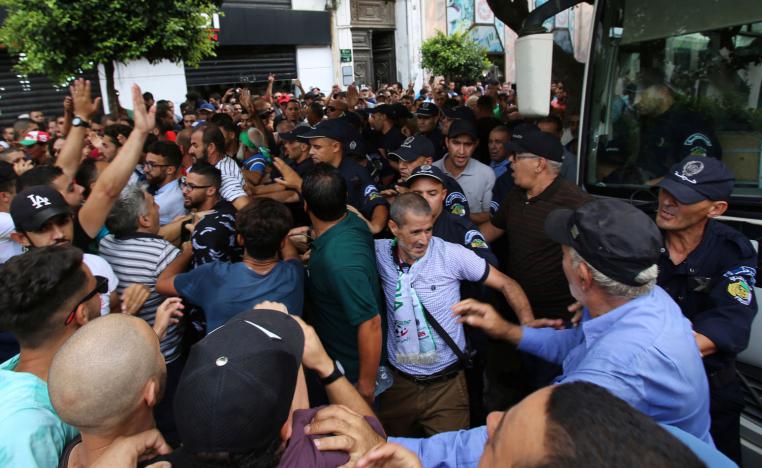 Police officers stand guard as demonstrators try to force their way during a protest