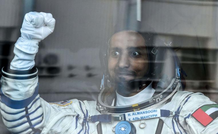 United Arab Emirates' astronaut Hazza Al Mansouri raises his fist from a bus before boarding a Soyuz rocket to the International Space Station