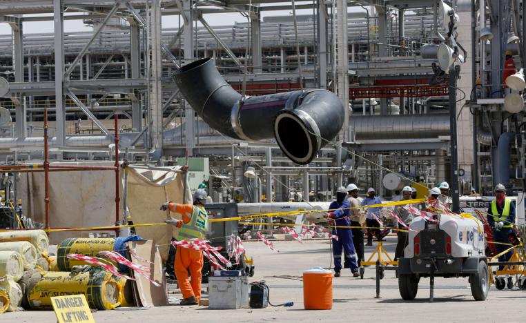 Workers replace a damaged tube at Saudi Aramco's Khurais oil field