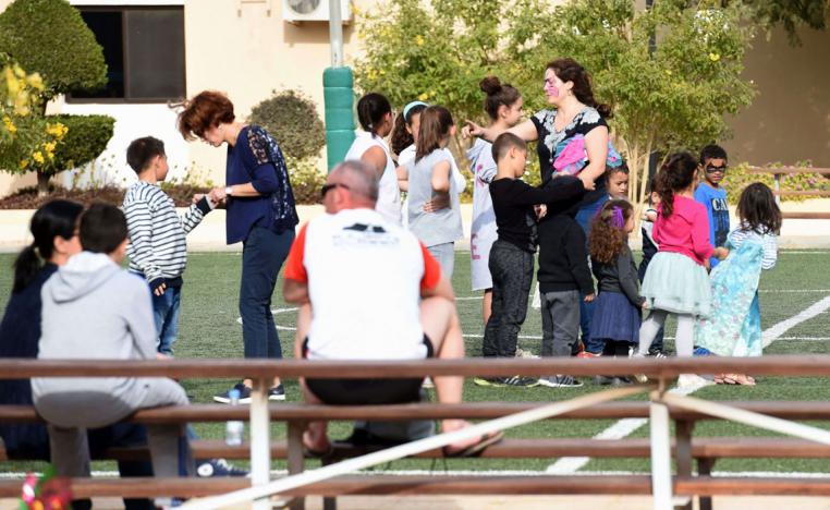 Western expatriates participate in leisure activities with their children in a compound in Riyadh
