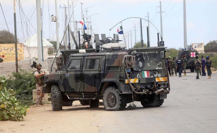 Italian security forces are seen near armoured vehicles at the scene of an attack on an Italian military convoy in Mogadishu
