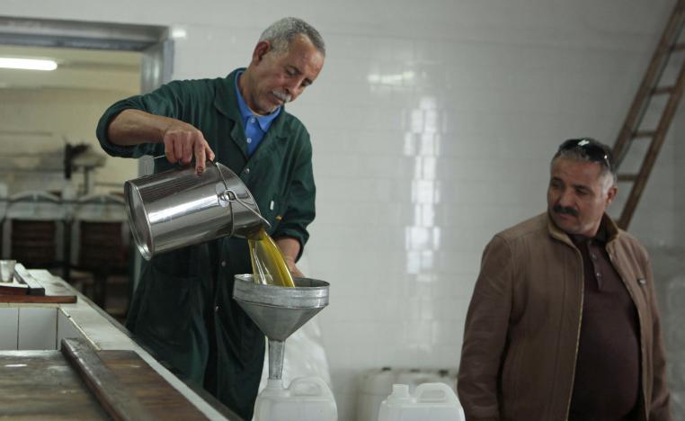 A worker pours olive oil at a traditional factory in Tebourba, 30km from Tunis