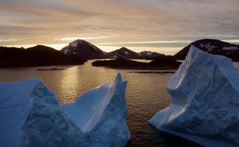 An aerial view of large Icebergs floating as the sun rises near Kulusuk, Greenland