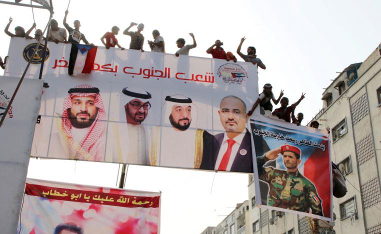 Supporters of Yemen's STC stand on a billboard during a rally