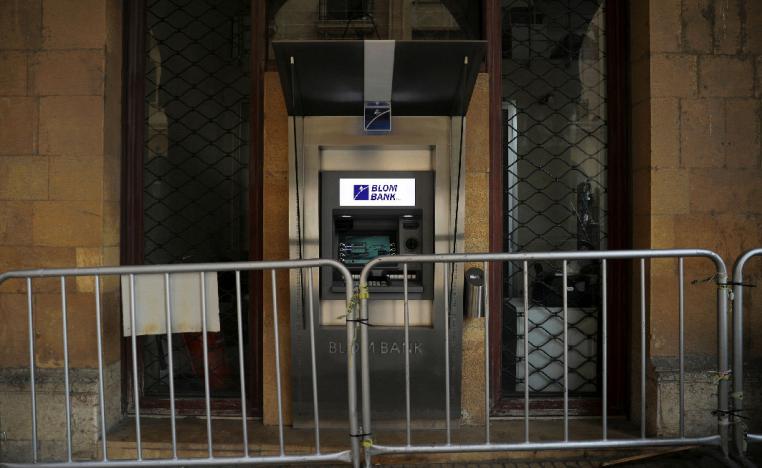 Metal barriers are set in front of an ATM at a closed Blom Bank branch in downtown Beirut
