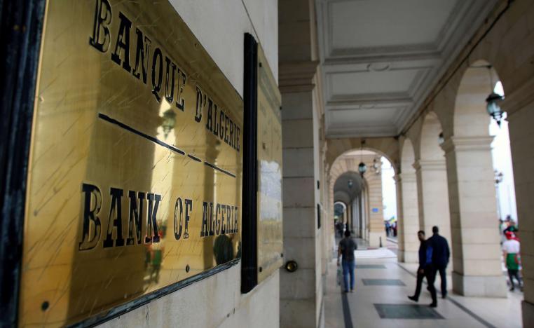 People walk past Bank of Algeria in Algiers