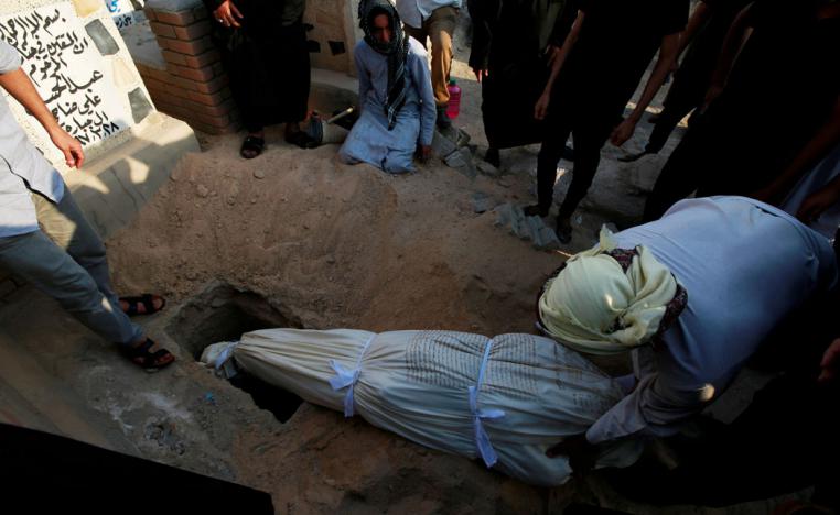 Iraqi men bury a demonstrator, who was killed during anti-government protests, at the cemetery in Najaf