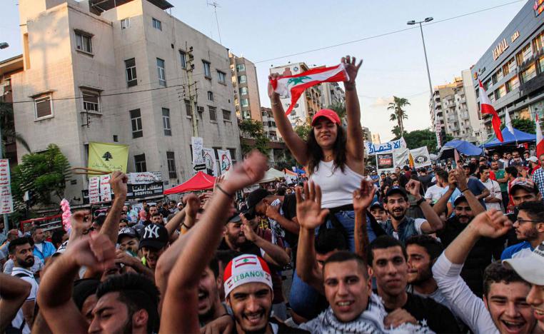 Lebanese anti-government protesters celebrate the resignation of Prime Minister Saad Hariri in Sidon