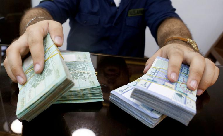 A money exchange vendor displays Lebanese pound banknotes at his shop in Beirut