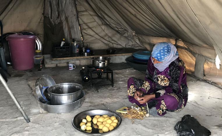A woman prepares food in the Mabrouka camp, near Ras al-Ain, Syria