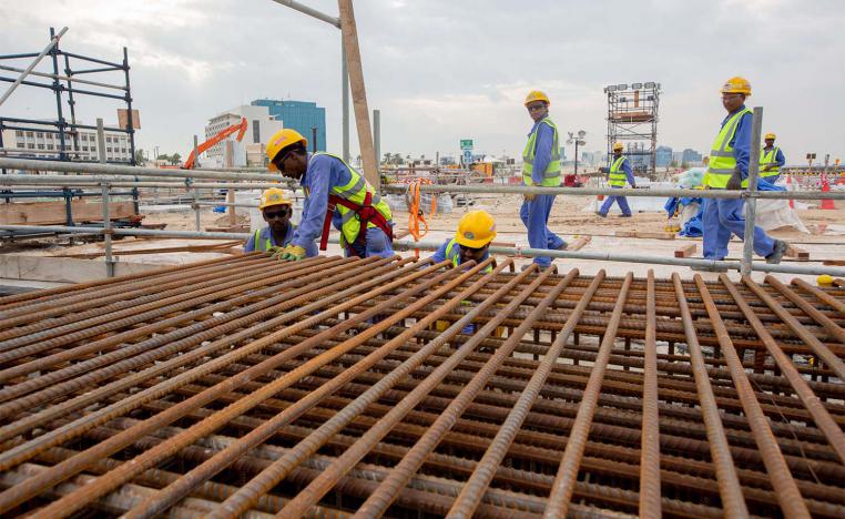 Construction workers work at the site of the Ras Abu Aboud Stadium in Doha