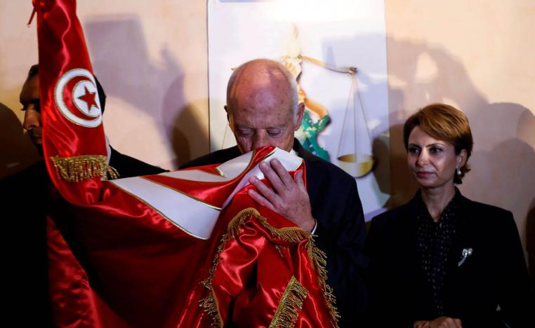 المرشح الرئاسي الفائز قيس سعيد يقبل علم بلاده