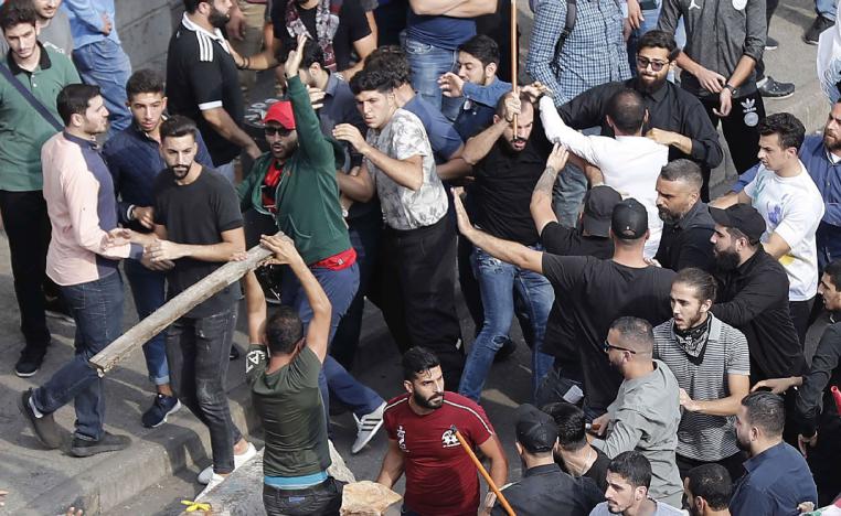 Anti-government protesters and Hezbollah supporters clash during a protest near the government palace, in downtown Beirut