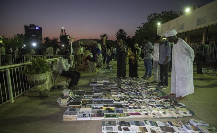 سودانيون يتجمعون حول كتب مفروشة على الأرض في معرض "مفروش"