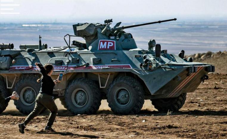 Kurdish demonstrators hurl rocks at a Russian military vehicle on November 8, 2019, during a joint Turkish-Russian patrol