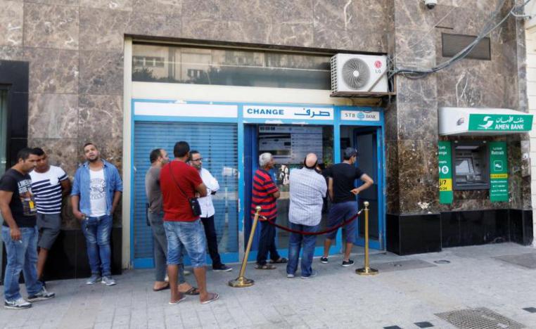 People change money at a currency exchange bank in Tunis