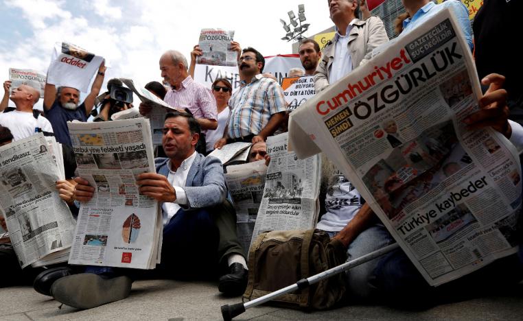 Press freedom activists read opposition newspaper Cumhuriyet during a demonstration
