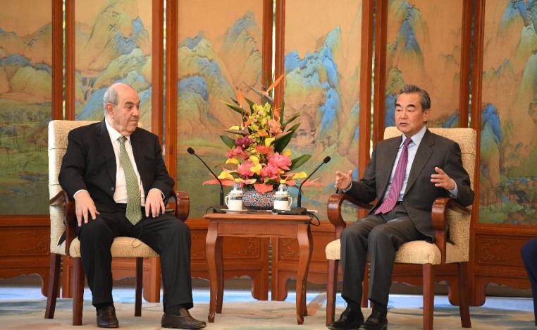 China's Foreign Minister Wang Yi talks to former Iraqi foreign minister Ayad Allawi during the Middle East Security Forum in Beijing