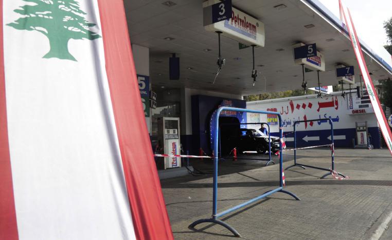 A Lebanese national flag hangs in front of a closed petrol station in the capital Beirut on November 9, 2019
