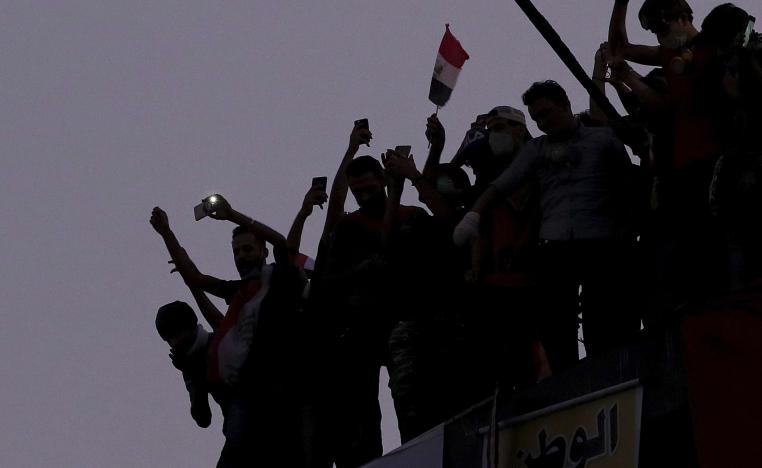 Iraqi anti-government protesters burn the Iranian flag during a demonstration in Baghdad