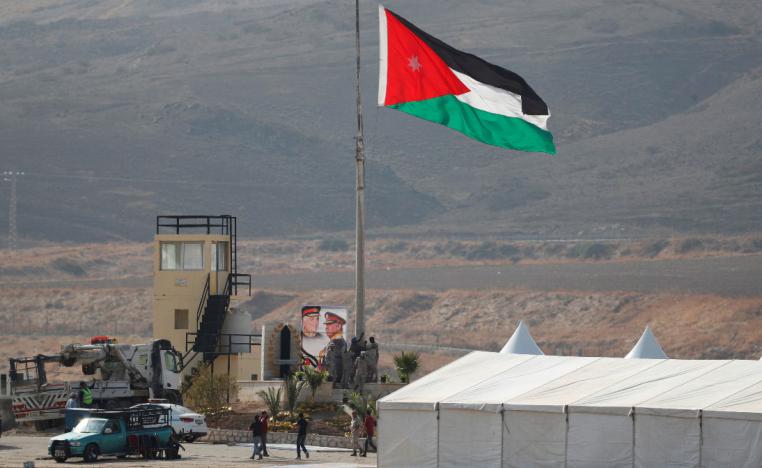 A Jordanian national flag is lifted near a tent at the "Island of Peace" in Baqura