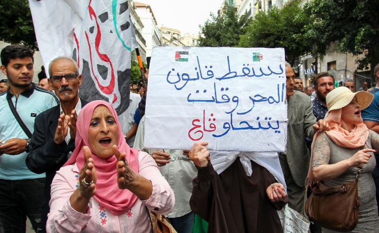 Algerian demonstrators hold a placard that reads in Arabic "down with the hydrocarbons law" in Algiers