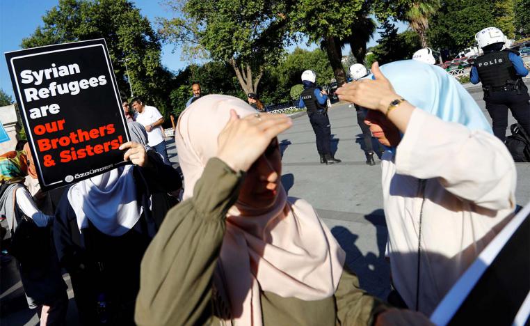 A demonstrator holds a placard in support of Syrian in Istanbul during a protest against Turkish government's recent refugee policies in Istanbul