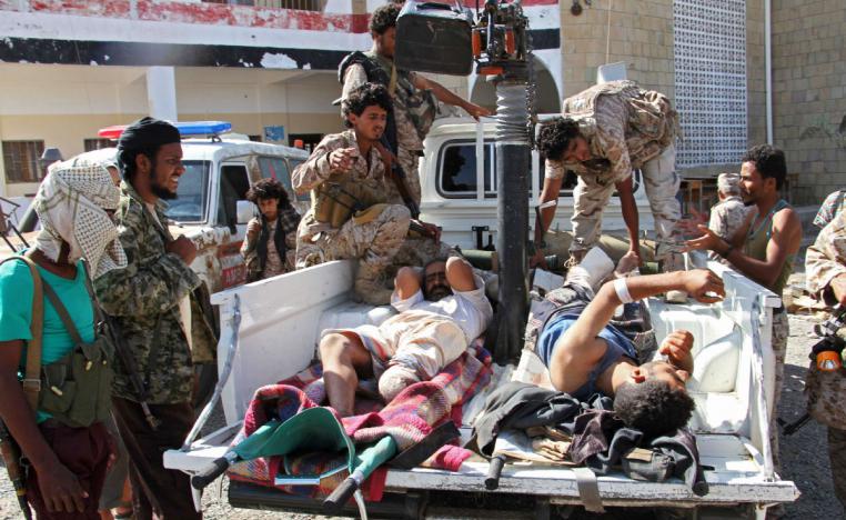 Fighters loyal to the Saudi-backed Yemeni president carry injured men onto the back of a pick-up truck in the western Yemeni coastal town of Mokha
