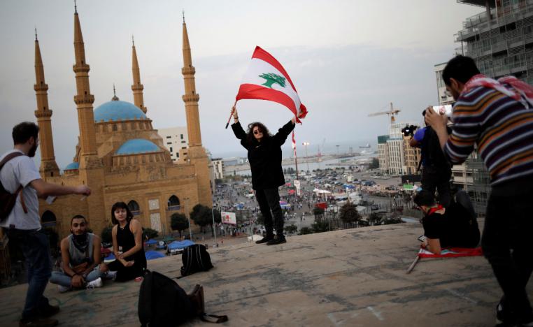 A woman holds a Lebanese flag