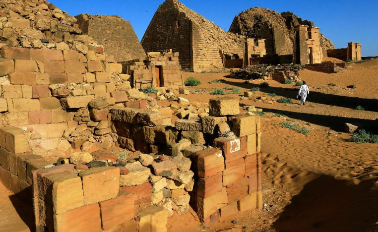 A man walks past the Royal Cemeteries of Meroe Pyramids in Begrawiya