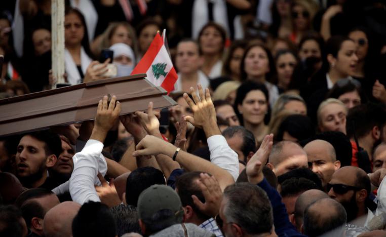 Mourners carry the cover of the coffin of Alaa Abou Fakher during the funeral in Choueifat